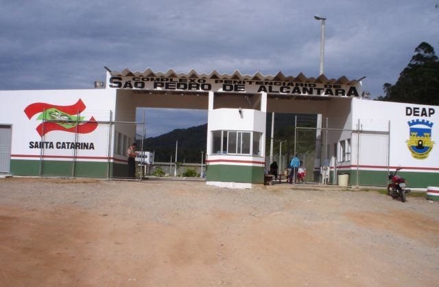 Bandidos tentam jogar objetos dentro de penitenciária, trocam tiros com agentes, um é morto e dois são presos